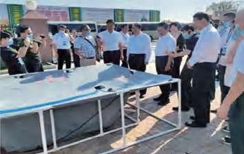公司工作人员时任农业农村部党组副书记、副部长刘焕鑫，时任河南省省长武国定介绍国基亿龙数字软体集雨水窖产品。